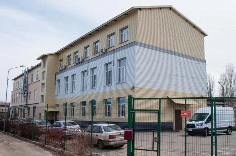 Three-storey production building behind a fence